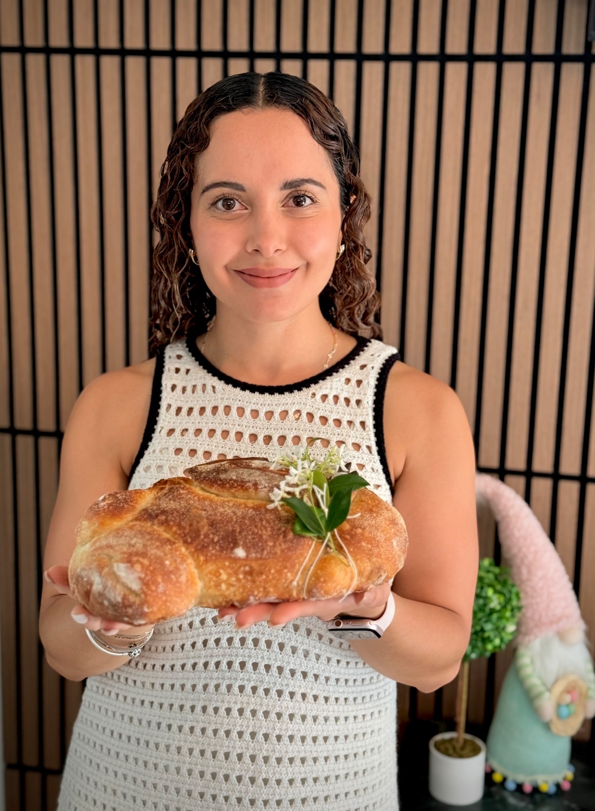 Stephanie smiling down at a sandwich loaf in natural window light